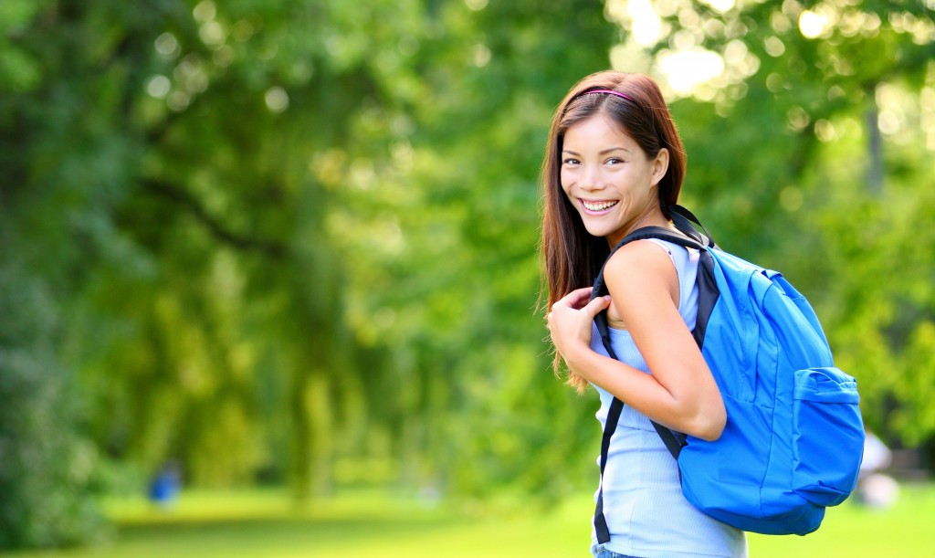Student girl portrait wearing backpack outdoor in park smiling h